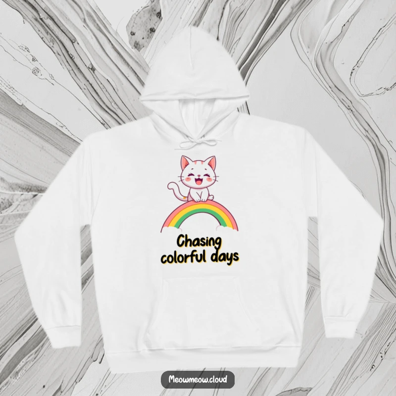 Funny hoodie with a cheerful cat character riding a rainbow arch like a slide, offering cozy comfort and whimsical fun.